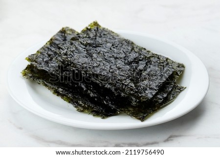 Selected Focus Korean Style Seaweed, Roasted Nori Laver, Ready to Eat. On White Plate, Isolated