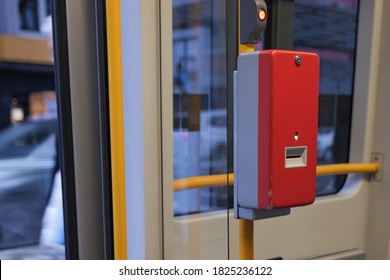 Selected Focus At Red Public Transportation Ticket Stamp Or Validation Ticket Machine Beside Opening Automatic Door Of Light Rail Tram Which Stop At Platform Train Station In Germany.