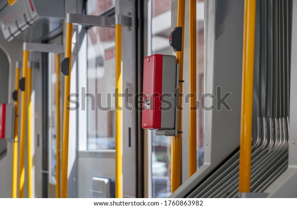 Selected focus at Red public\
transportation ticket stamp or validation ticket machine in front\
of automatic door of light rail tram in Düsseldorf,\
Germany.