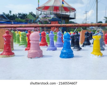 Selected Focus Shot Of Colorful Chess Pawns On Blurred Merry Go Round Background