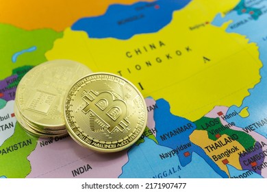 Selected focus Stack of gold bitcoin coins with China on a world map background.