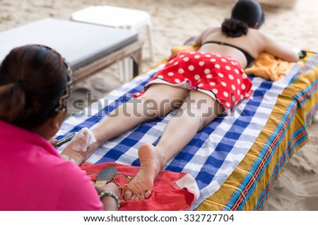 Selected focus Woman having foot scrub on the beach