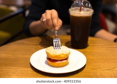 Selected Focus Woman Holding Fork Eating Scone With Iced Coffee On The Table