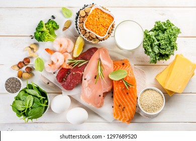 Selection Of Animal And Plant Protein Sources - Fish, Meat, Beans, Cheese, Eggs, Nuts And Seeds, Kale, On Wood Background