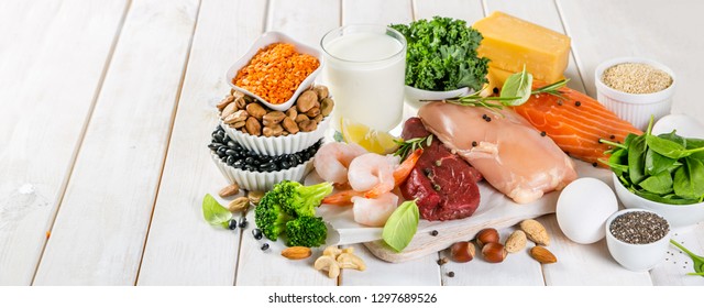 Selection Of Animal And Plant Protein Sources - Fish, Meat, Beans, Cheese, Eggs, Nuts And Seeds, Kale, On Wood Background