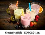 Selection of bubble tea in a tea house with assorted fruit flavors, caramel and chocolate with fresh ingredients on a wooden table viewed high angle