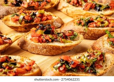 Selection of crispy toasted bread slices topped with fresh tomato, basil and pesto mixture creating a colorful Italian appetizer perfect for Mediterranean dining.