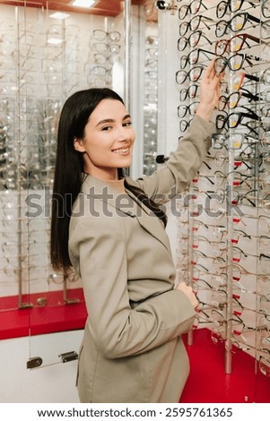 Selection of eyeglasses with different frames. High quality eyeglasses with clear lenses. Female client chooses eyeglasses from the stand in the optical store.
