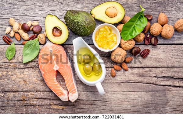 Selection food sources of omega 3 and\
unsaturated fats. Superfood high vitamin e and dietary fiber for\
healthy food. Almond,pecan,hazelnuts,walnuts,olive oil,fish oil and\
salmon on wooden\
background.