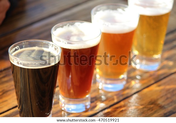 A selection of four craft beers during a tasting session on a wooden table