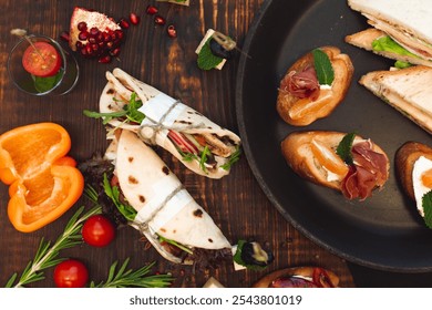 A selection of gourmet appetizers including wraps, bruschetta with prosciutto and mandarin, cherry tomatoes, and fresh herbs on a rustic table setting.
 - Powered by Shutterstock