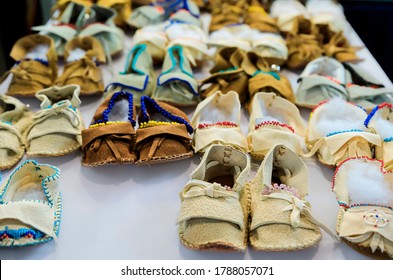 Selection of handmade kids and baby beaded leather Native American Indian moccasins on display for sale at a powwow in San Francisco - Powered by Shutterstock