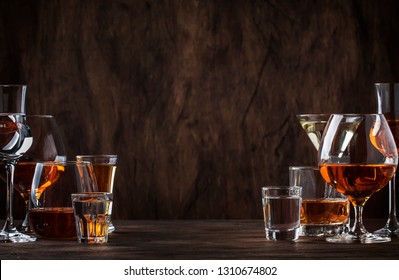 Selection of hard strong alcoholic drinks big glasses and shot glass in assortent: vodka, cognac, tequila, brandy and whiskey, grappa, liqueur, vermouth, tincture, rum.  - Powered by Shutterstock