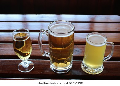 A selection of lager, cider and wheat beer in differently shaped glasses on a wooden table in a craft brewery during a beer tasting