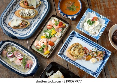 Selection Of Many Different Mixed Tapas On Rustic Wood Table   In Barcelona Restaurant