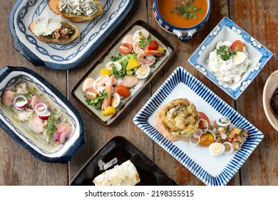 Selection Of Many Different Mixed Tapas On Rustic Wood Table   In Barcelona Restaurant