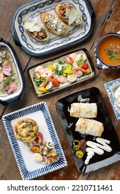 Selection Of Many Different Mixed Tapas On Rustic Wood Table   In Barcelona Restaurant