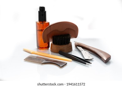 A Selection Of Men's Beard Grooming Products That Include Oil, Cut Throat Razor And A Brush, Shot Against A Clean White Background