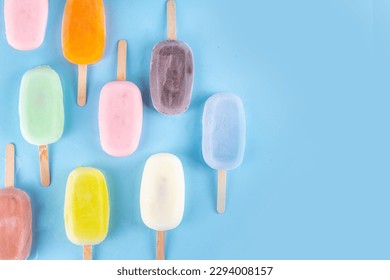 Selection of multicolored ice cream popsicles. Various flavor gelato, frozen lollypops - chocolate vanilla blueberry strawberry pistachio orange, on light blue background