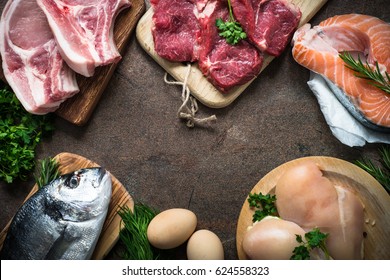 Selection of protein sources at stone table. Meat, chicken, fish, egg. Top view with copy space.