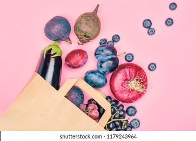 Selection of purple foods - fruits, berries and vegetables in a grocery craft bag on pink background. Purple or eat by color diet concept. Copy space - Powered by Shutterstock