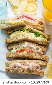 Selection of sandwiches on malted brown bread. Prawns with mayonnaise. Roast chicken breast, vine tomatoes, cucumber, mayonnaise. Egg mayonnaise  and watercress. Ham and cheddar cheese on mayo. 