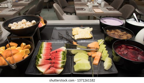 Selection of self service catering continental breakfast buffet display, catering or brunch table food buffet filled with fresh fruits, cereals and milk in a hotel or restaurant setting