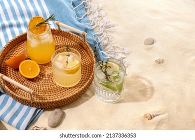 Selection of summer alcoholic cocktails on a wicker tray on beach with white sand. Summer sea vacation and travel concept. Exotic summer drinks.