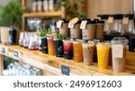 A selection of takeaway drinks, including coffee cups and cold beverages, displayed on a counter. The drinks are in eco-friendly, branded packaging, ready for customers on the go.