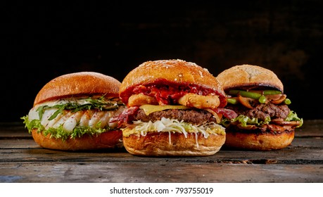 Selection Of Three Different Gourmet Burgers With A Fish Seafood Burger, Surf And Turf With Bacon And Squid And Avocado And Guacamole Burger