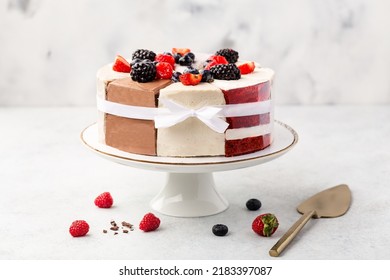 Selection Of Various Cake Pieces - Cheesecake, Chocolate Cake, Red Velvet On Cake Stand On White Stone Background With Berries. Overhead View, Flat Lay