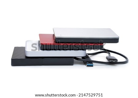 Selection of various compact 2.5 inch hard disk drives with a connection cable isolated on white background.