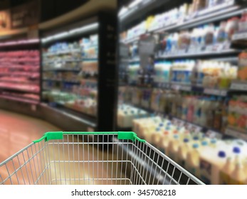 Selection Of Yogurts, Soy Milk And Milk On The Shelves In A Supermarket With Shopping Cart