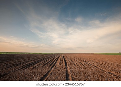 Selective blur on furrows on a Agricultural landscape near a farm, a plowed field in the countryside of Titelski, Serbia, Voivodina. The plough is a technique used in agriculture to fertilize a land.