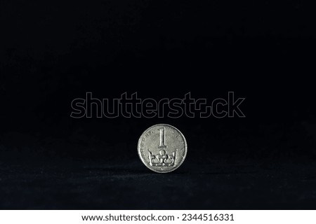 Selective blur on a one czech crown coin with the mention one crown written in czech, isolated on a black background. CZK, or Czech crown, or koruna, is the official currency and money of Czechia.