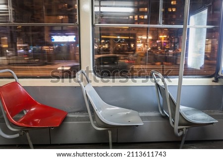 Selective blur on three empty plastic seats in an old vintage tram in belgrade, serbia, at night, with a speed blur in the background. Belgrade tram is one of public transportation systems of the city