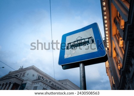 Selective blur on a tram stop sign in Riga, Latvia, at dusk, indicating the presence of a tram stop connected to public transportation routes.