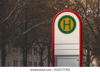 Selective blur on a typical austrian and german bus stop sign, called haltestelle, or bushaltestelle, in a dortmund urban environment. it indicates the presence of a public transportation stop station