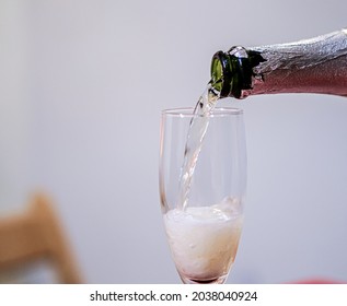 A selective of a champaign being poured into a glass in a room