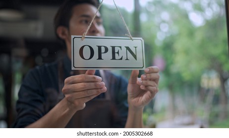 Selective, Close Up Handsome Young Man Owner Turning Storefront Sign To Open At Cafe Or Restaurant, Small Business Service Concept