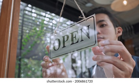 Selective, Close Up Handsome Young Man Owner Turning Storefront Sign To Open At Cafe Or Restaurant, Small Business Service Concept