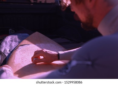 A Selective Closeup Shot Of A Person Carving On A Surfboard