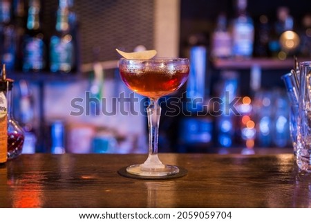 A selective of a cocktail in a glass on a wooden table in a bar
