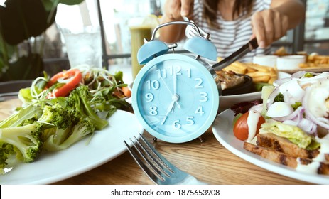 Selective focus of 07. 00 AM clock and breakfast time, Alarm clock intermittent fasting as a healthy and balanced breakfast - Shutterstock ID 1875653908