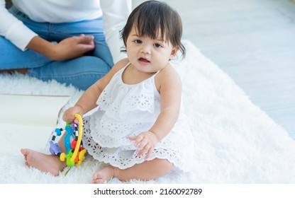 Selective Focus Adorable Caucasian Little Baby Daughter Girl, Smiling, Crawling On The Floor, Playing Alone In Comfortable Living Room At Home Or House With Happiness. Kid Development Concept