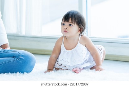 Selective Focus Adorable Caucasian Little Baby Daughter Girl, Smiling, Crawling On The Floor, Playing Alone In Comfortable Living Room At Home Or House With Happiness. Kid Development Concept