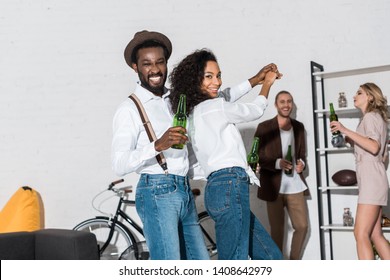 selective focus of african american man and woman dancing near friends 