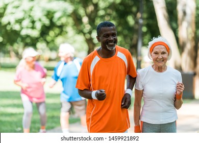 selective focus of african american senior man and retired woman exercising near pensioners outside  - Powered by Shutterstock