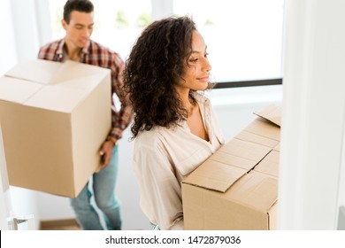 Selective Focus Of African American Woman Holding Box While Man Going Upstairs 