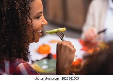 Selective Focus Of African American Woman Eating Asparagus During Thanksgiving Dinner